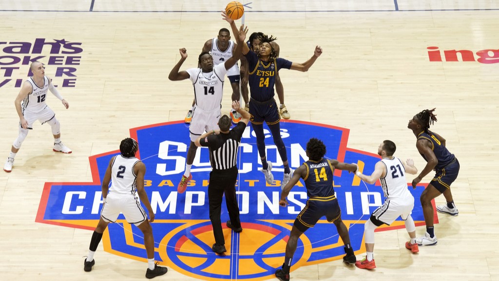 Basketball players leap during the tip-off of the Southern Conference basketball tournament game March 11, 2024, in Asheville.