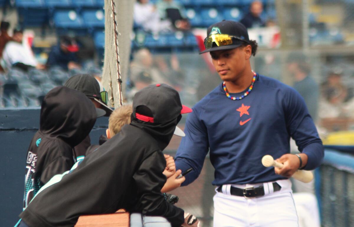 Asheville Tourist John Garcia chats with young fans outside the dugout prior to an exhibition game April 3, 2024, marking the 100th anniversary of McCormick Field.