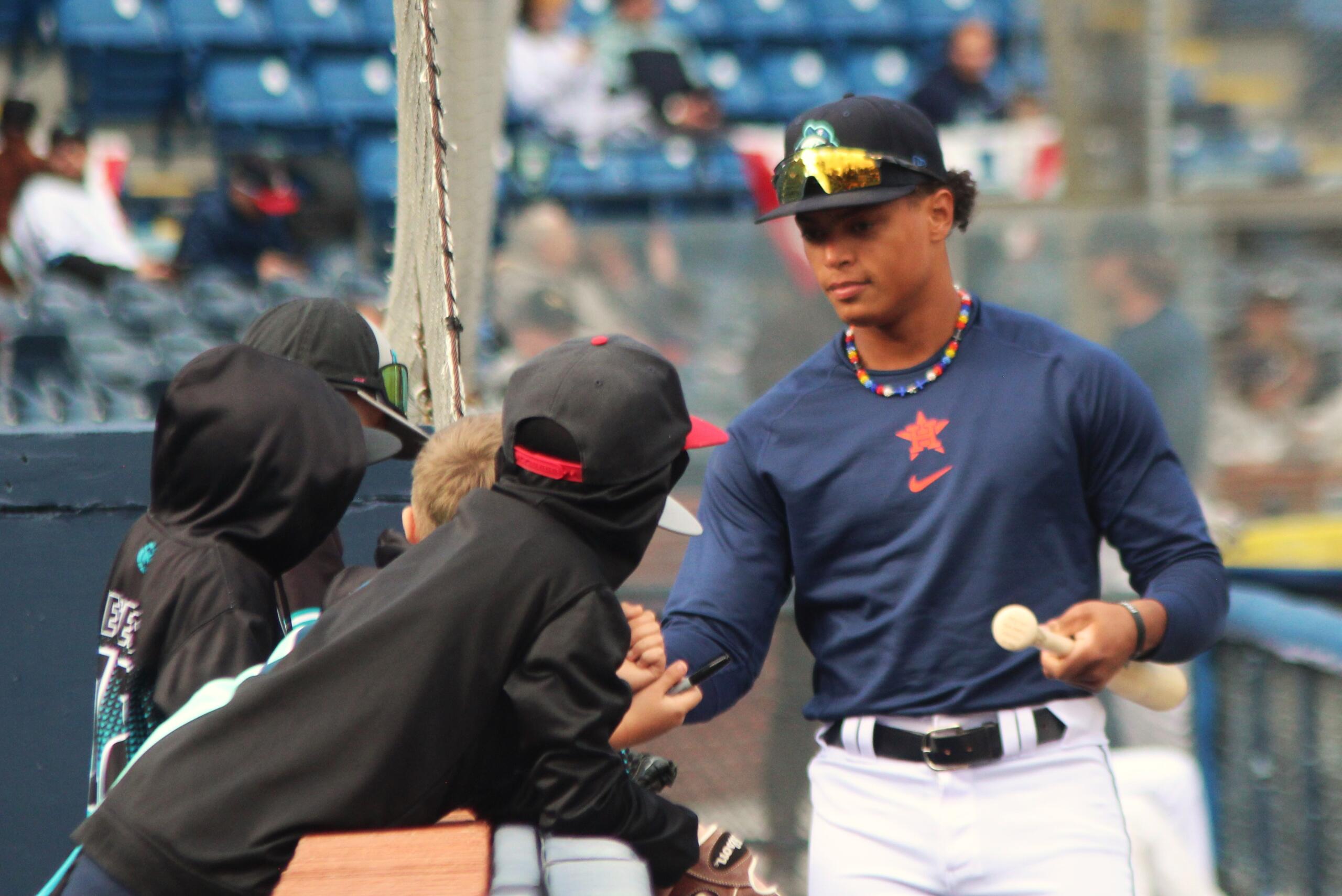 Asheville Tourist John Garcia chats with young fans outside the dugout prior to an exhibition game April 3, 2024, marking the 100th anniversary of McCormick Field.