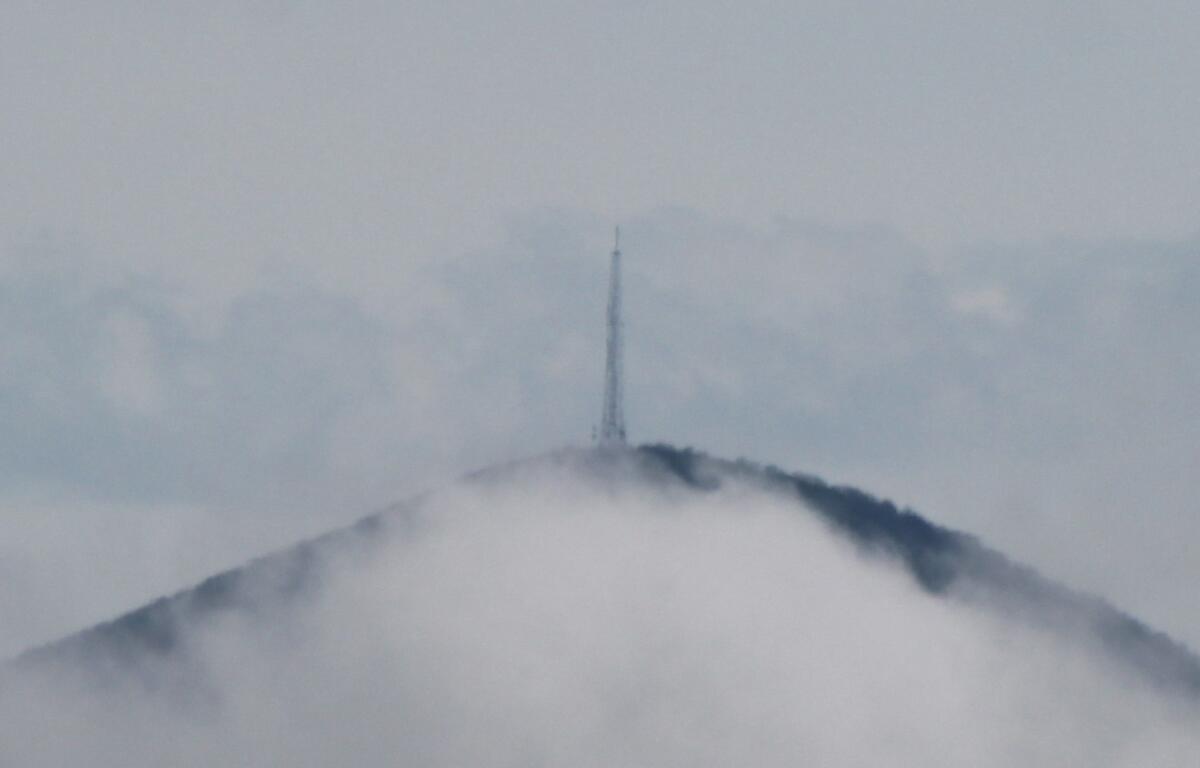 Mount Pisgah appears through the clouds on Saturday, April 20, 2024.