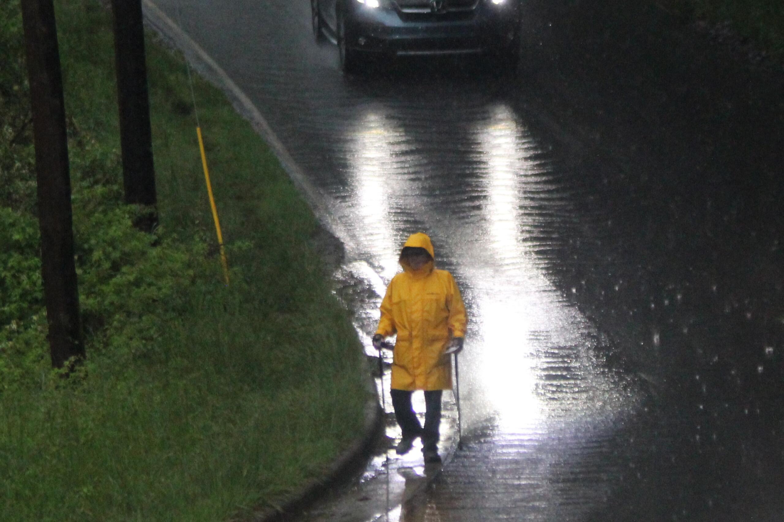 Christian "Chris" Lachance, 76, is undeterred by the rain as he makes his daily walk picking up trash on Hazel Mill Road in West Asheville.