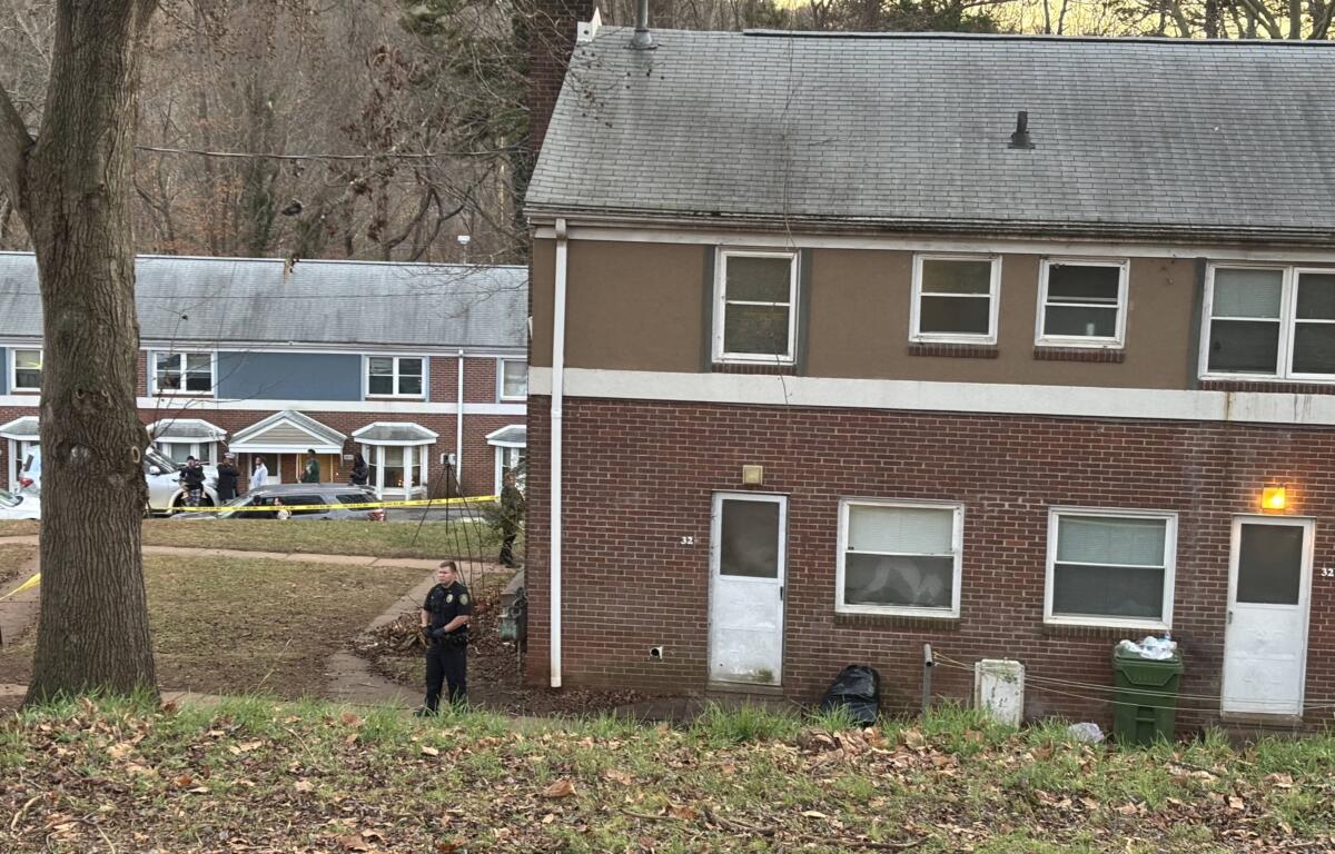 An officer stands outside the apartment complex where a double homicide was committed earlier today, Monday, Dec. 16.