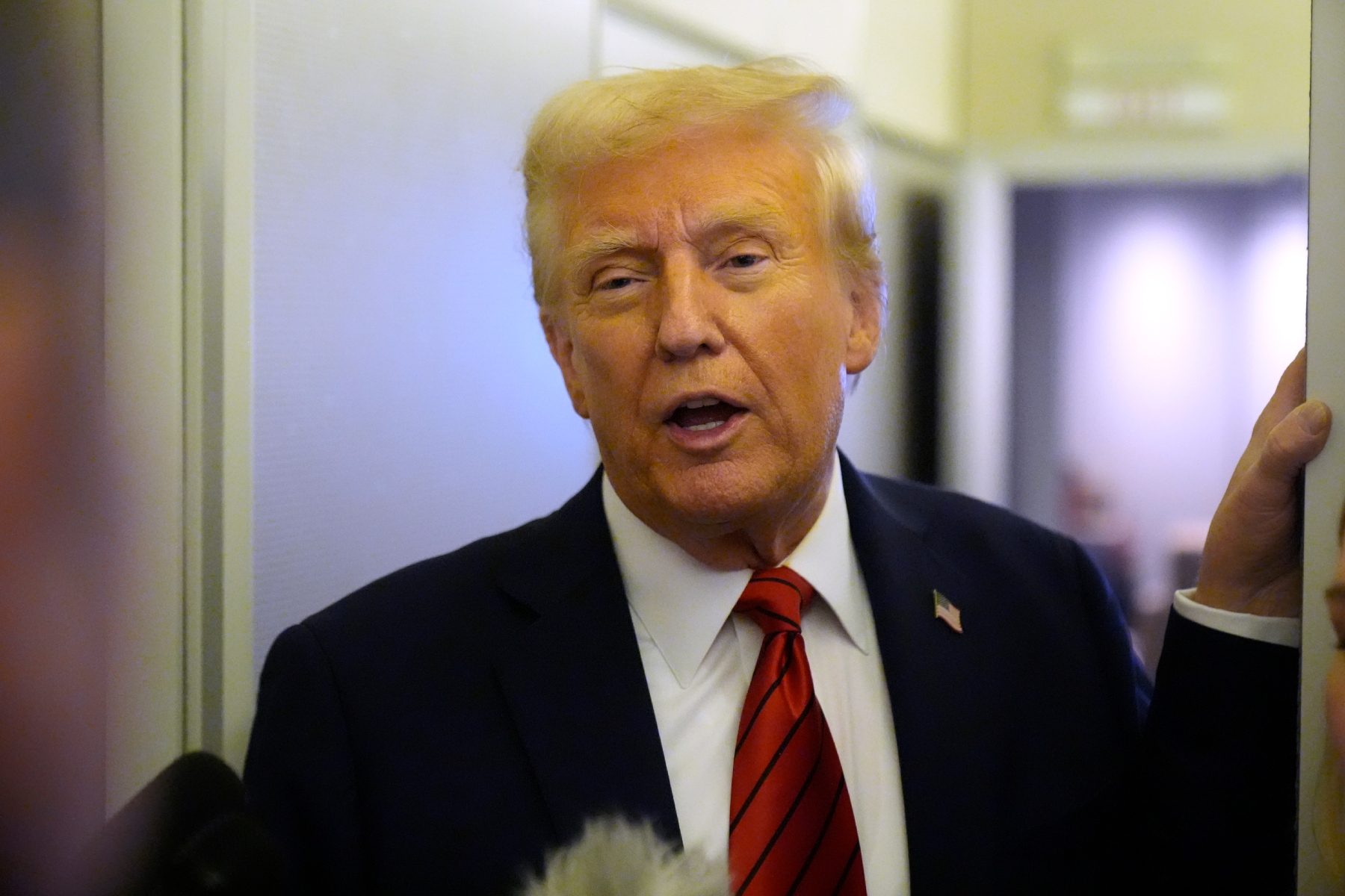 President Donald Trump speaks to reporters aboard Air Force One en route from Miami to Joint Base Andrews, Md., Monday, Jan. 27, 2025. (AP Photo/Mark Schiefelbein)