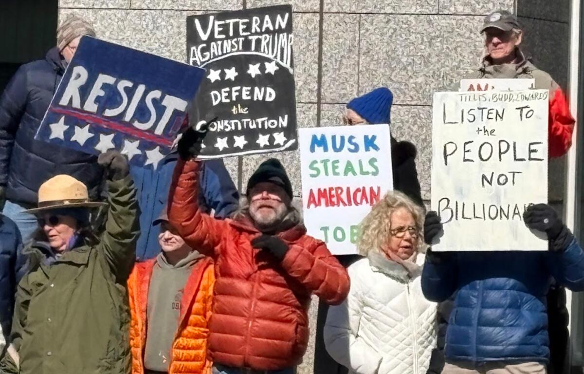 Protesters gathered in front of the Veach-Baley Federal Building at noon Friday, Feb. 21, 2025.