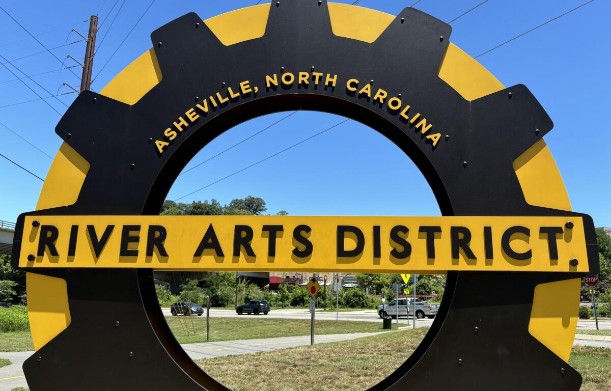 A sculpture sign shaped like a gear announcing the River Arts District.