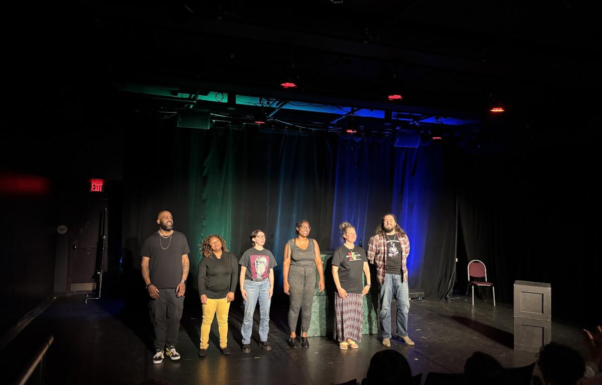 Actors stand onstage after a performance.