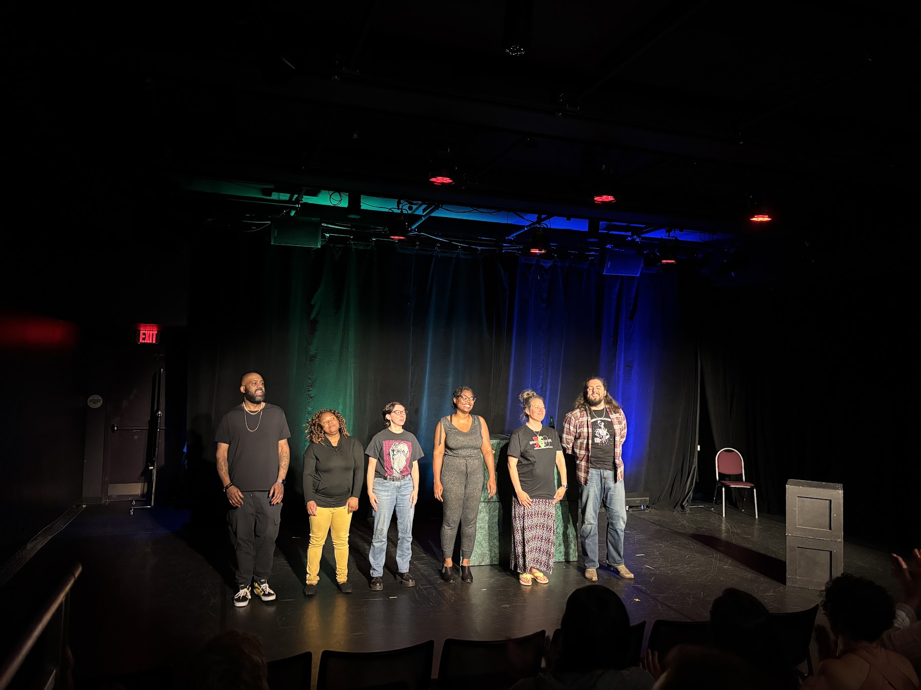 Actors stand onstage after a performance.
