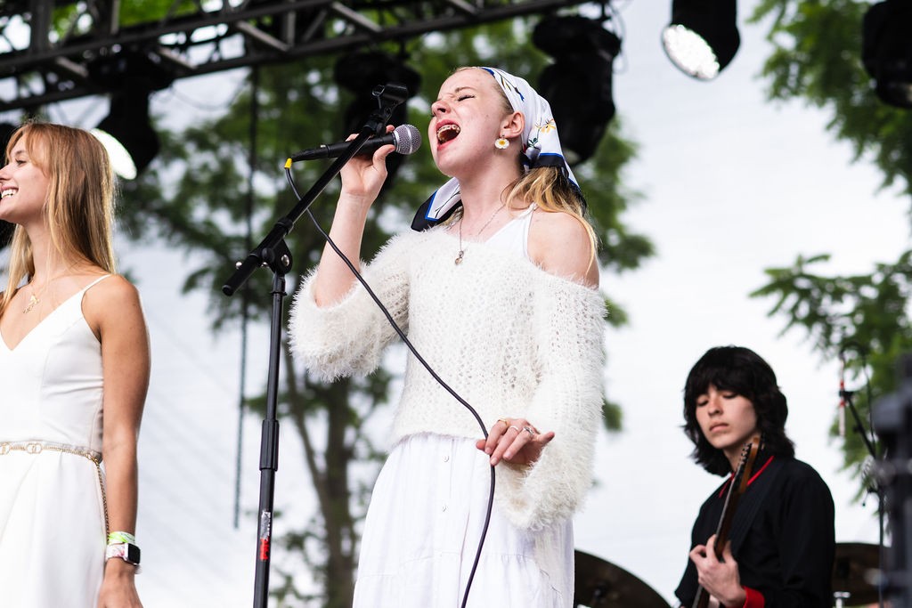 A young woman sings onstage at a concert.