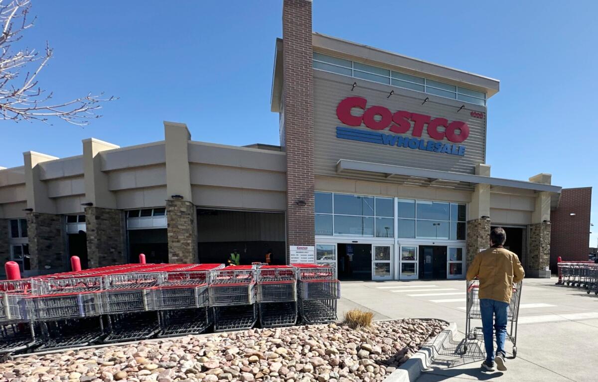 FILE - A lone shopper pushes a cart toward the entrance of a Costco warehouse, March 13, 2025, in Sheridan, Colo. (AP Photo/David Zalubowski, File)