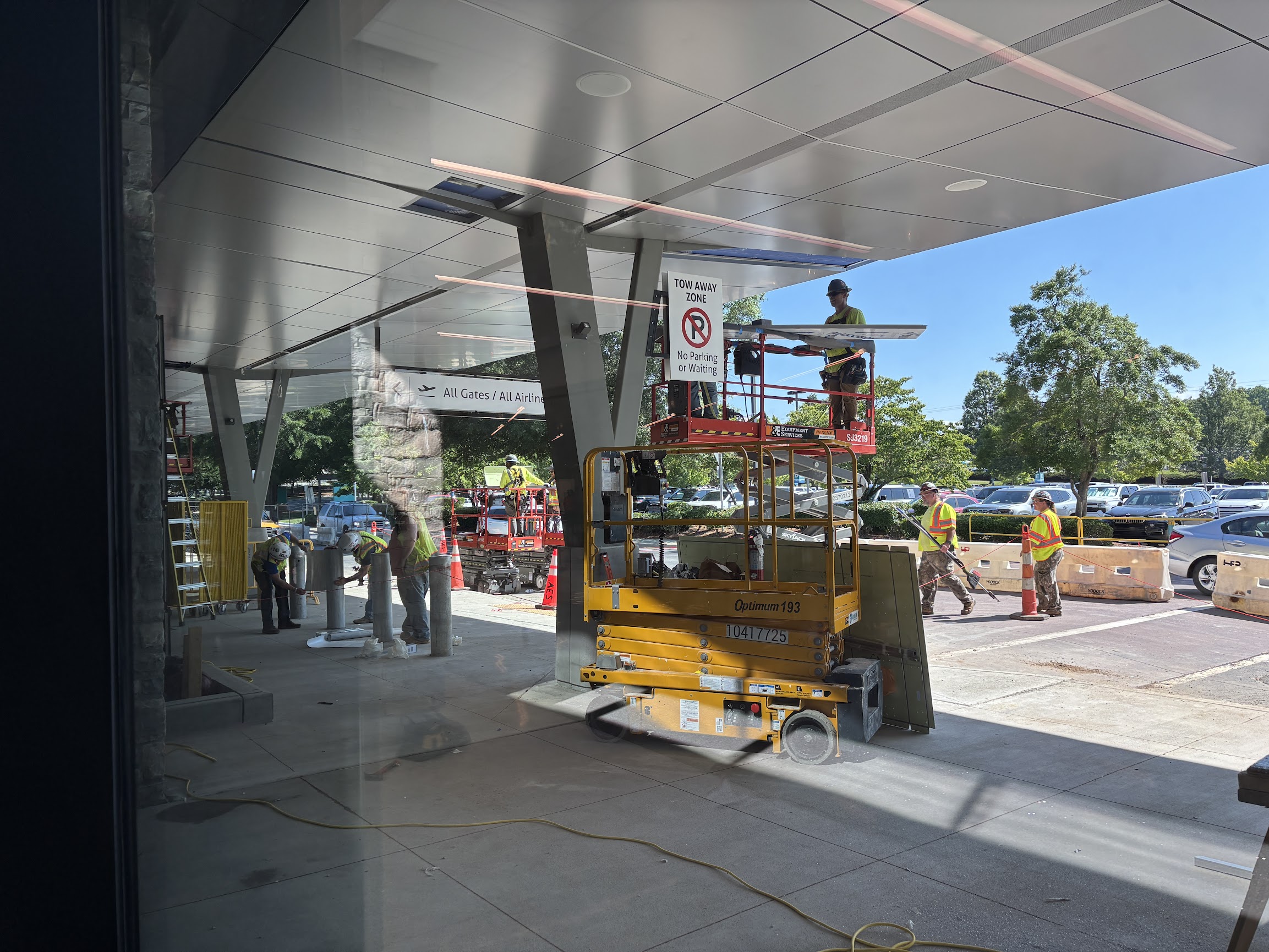Construction workers operate outside at an airport.