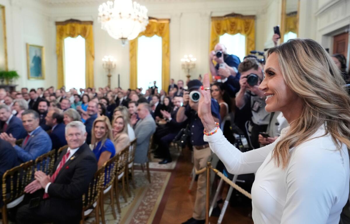 Lara Trump waves to the audience as President Donald Trump speaks at an event for the signing of the GENIUS Act, a bill that regulates stablecoins, a type of cryptocurrency, in the East Room of the White House, Friday, July 18, 2025, in Washington. (AP Photo/Alex Brandon)