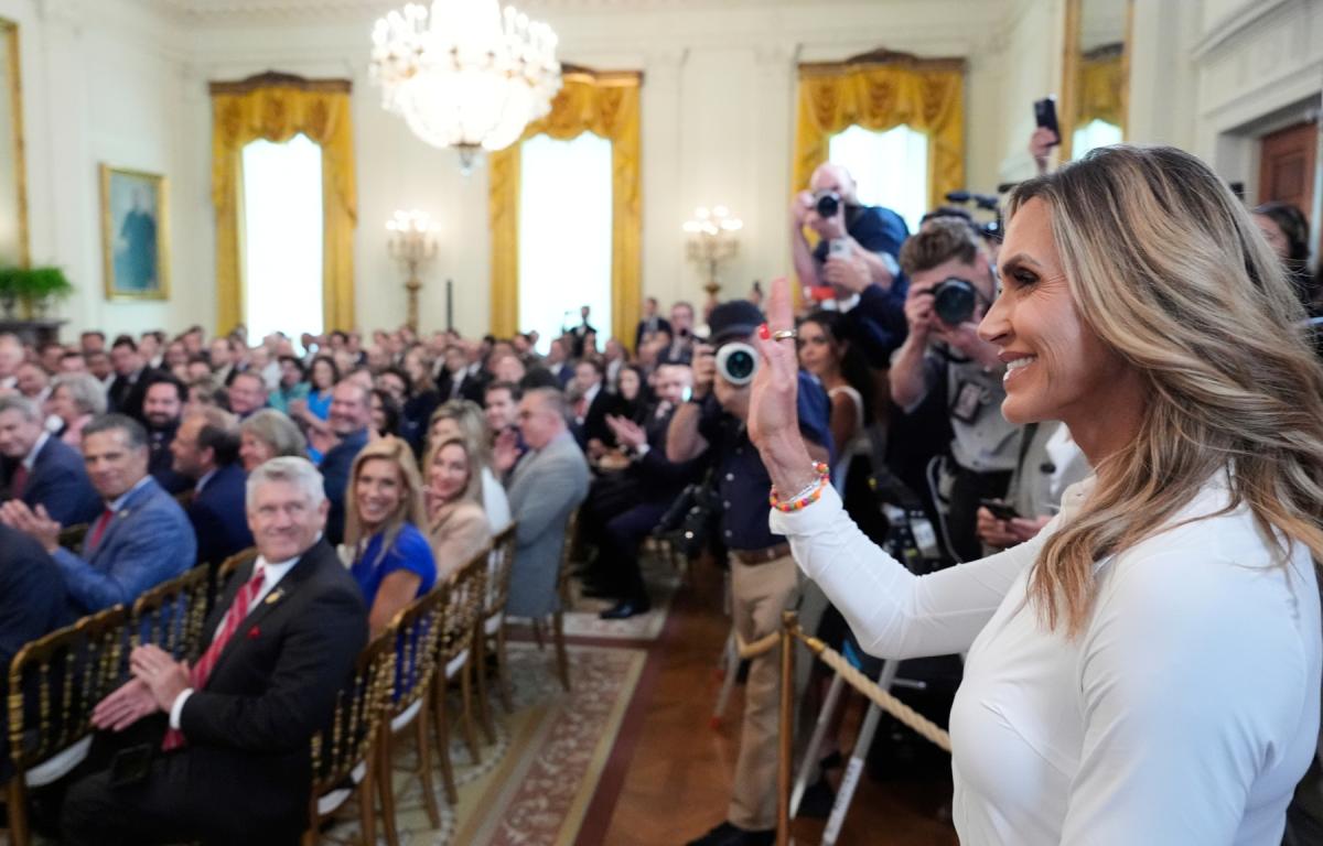Lara Trump waves to the audience as President Donald Trump speaks at an event for the signing of the GENIUS Act, a bill that regulates stablecoins, a type of cryptocurrency, in the East Room of the White House, Friday, July 18, 2025, in Washington. (AP Photo/Alex Brandon)