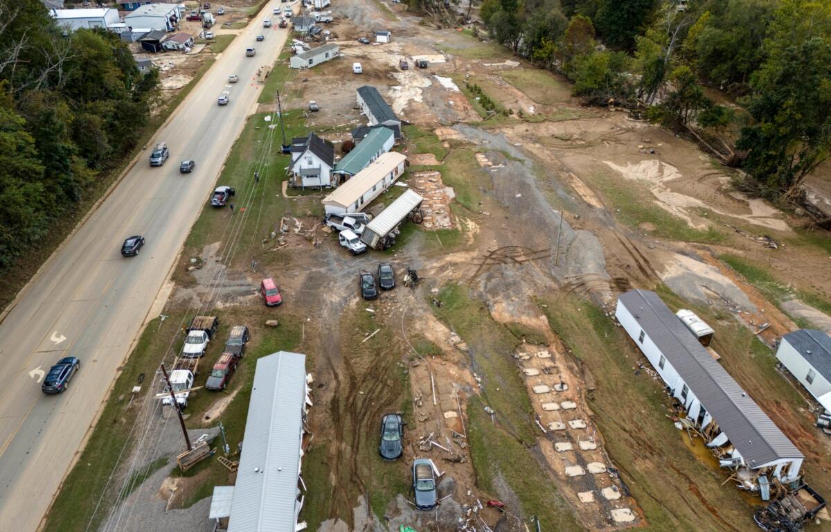 FILE - Homes and vehicles that were damaged in a flash flood from Hurricane Helene lie on the side of a road near the Swannanoa River, Tuesday, Oct. 1, 2024, in Swannanoa, N.C. (AP Photo/Mike Stewart, File)