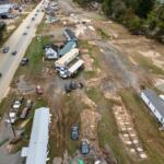 FILE - Homes and vehicles that were damaged in a flash flood from Hurricane Helene lie on the side of a road near the Swannanoa River, Tuesday, Oct. 1, 2024, in Swannanoa, N.C. (AP Photo/Mike Stewart, File)