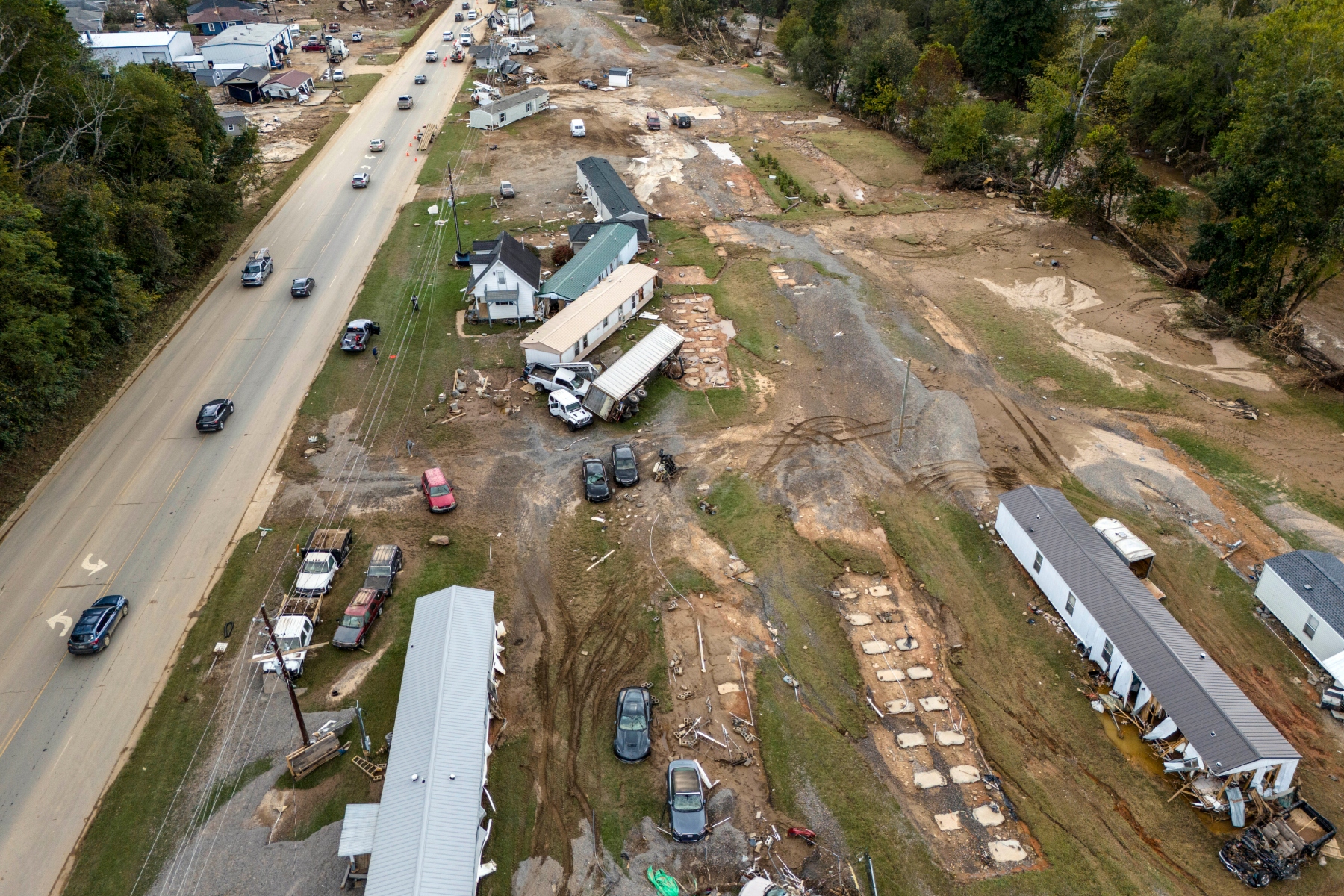 FILE - Homes and vehicles that were damaged in a flash flood from Hurricane Helene lie on the side of a road near the Swannanoa River, Tuesday, Oct. 1, 2024, in Swannanoa, N.C. (AP Photo/Mike Stewart, File)