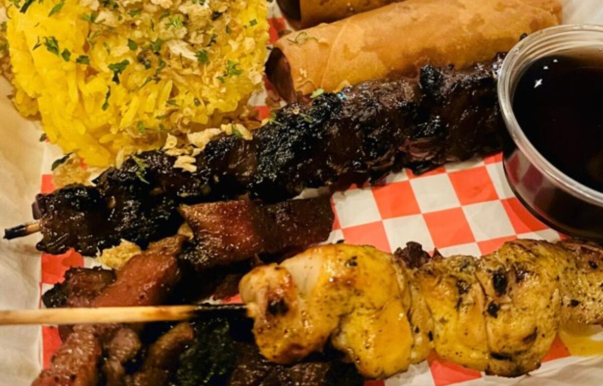 BBQ Sampler: skewers of chicken, pork and pork belly, grilled to perfection, paired with traditional yellow rice seasoned with garlic, turmeric and annatto extract.