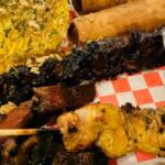 BBQ Sampler: skewers of chicken, pork and pork belly, grilled to perfection, paired with traditional yellow rice seasoned with garlic, turmeric and annatto extract.