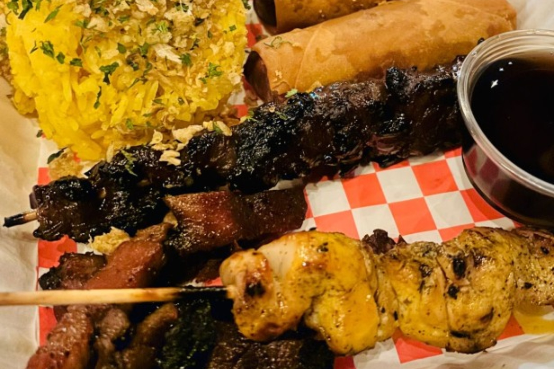 BBQ Sampler: skewers of chicken, pork and pork belly, grilled to perfection, paired with traditional yellow rice seasoned with garlic, turmeric and annatto extract.