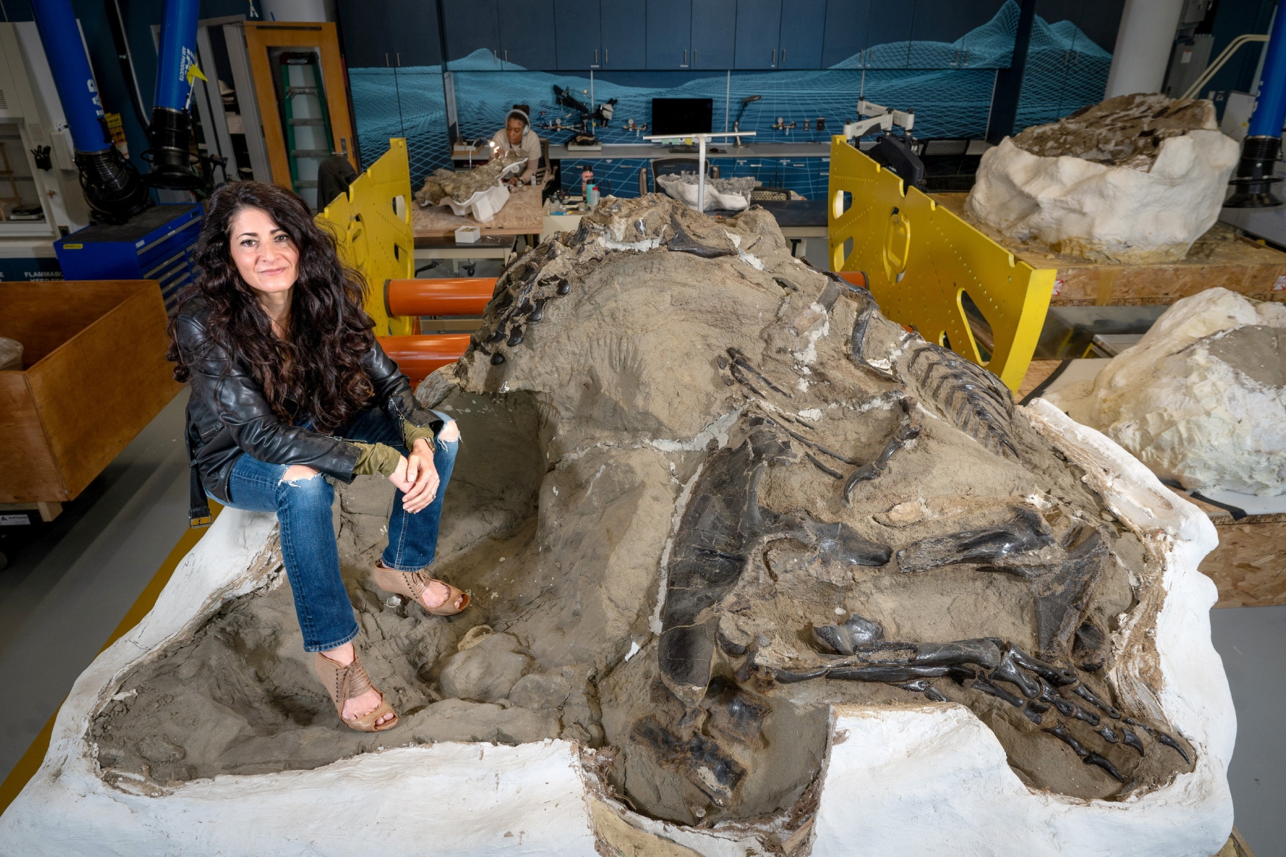 This image provided by North Carolina State University shows Associate Research Professor Lindsay Zanno posing with one of her dinosaur finds at the North Carolina Museum of Natural Sciences in downtown Raleigh, N.C. March 25, 2024. (Marc Hall/North Carolina State University via AP)