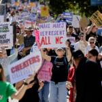 Marchers proceed from the Capitol during a rally protesting a proposed redistricting map Tuesday, Oct. 21, 2025, in Raleigh, N.C. (AP Photo/Chris Seward)