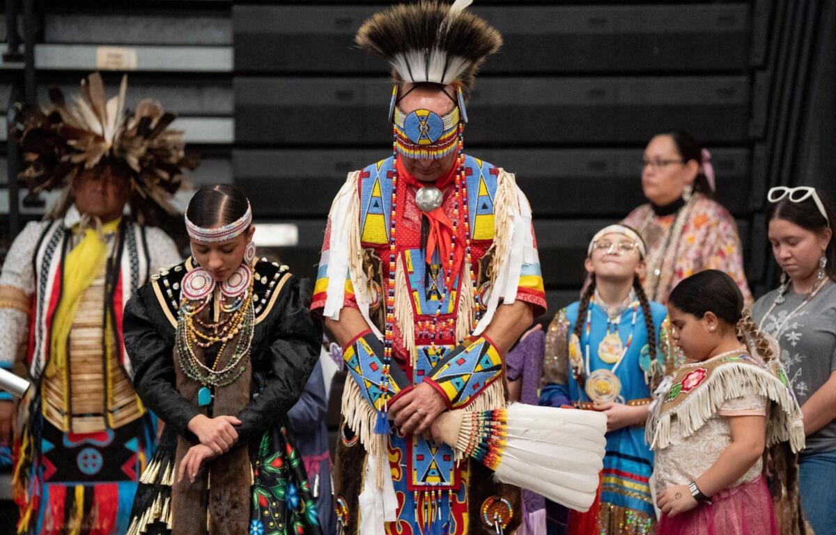 FILE - Members of the Lumbee Tribe bow their heads in prayer during the BraveNation Powwow and Gather at UNC Pembroke, March 22, 2025, in Pembroke, N.C. (AP Photo/Allison Joyce, file)