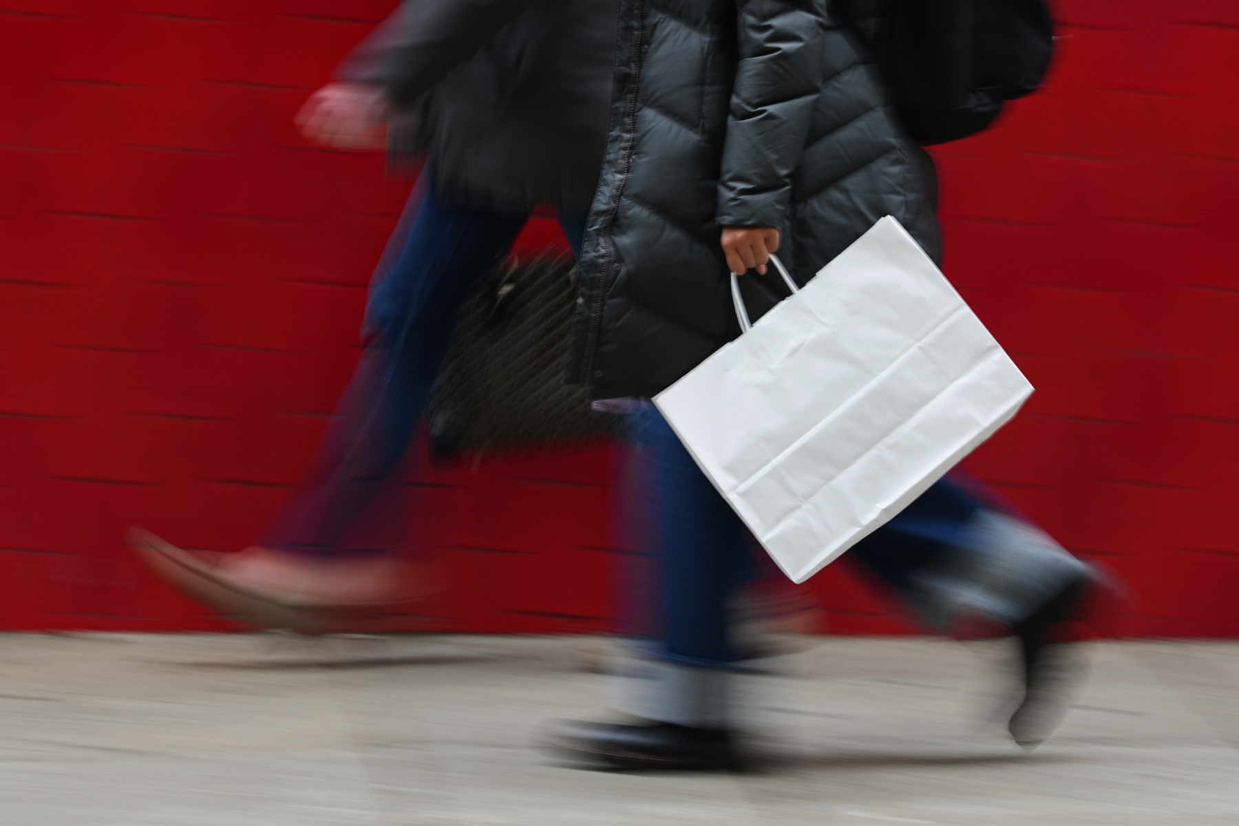 FILE - A person carries a shopping bag in Philadelphia, Dec. 10, 2025. (AP Photo/Matt Rourke, File)