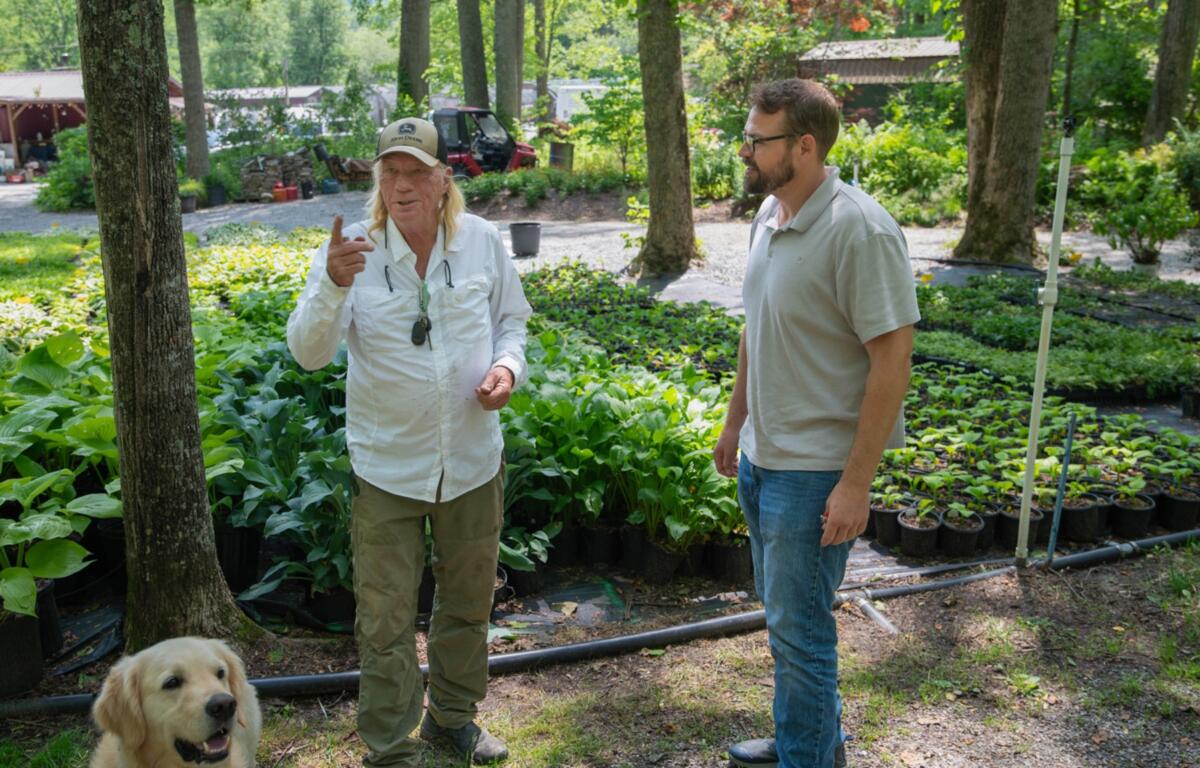Botanical Treasures owner Robert Stine (left) speaks with Blue Ridge Community College’s Small Business Center Director Ben Smith (right) several months after Hurricane Helene.