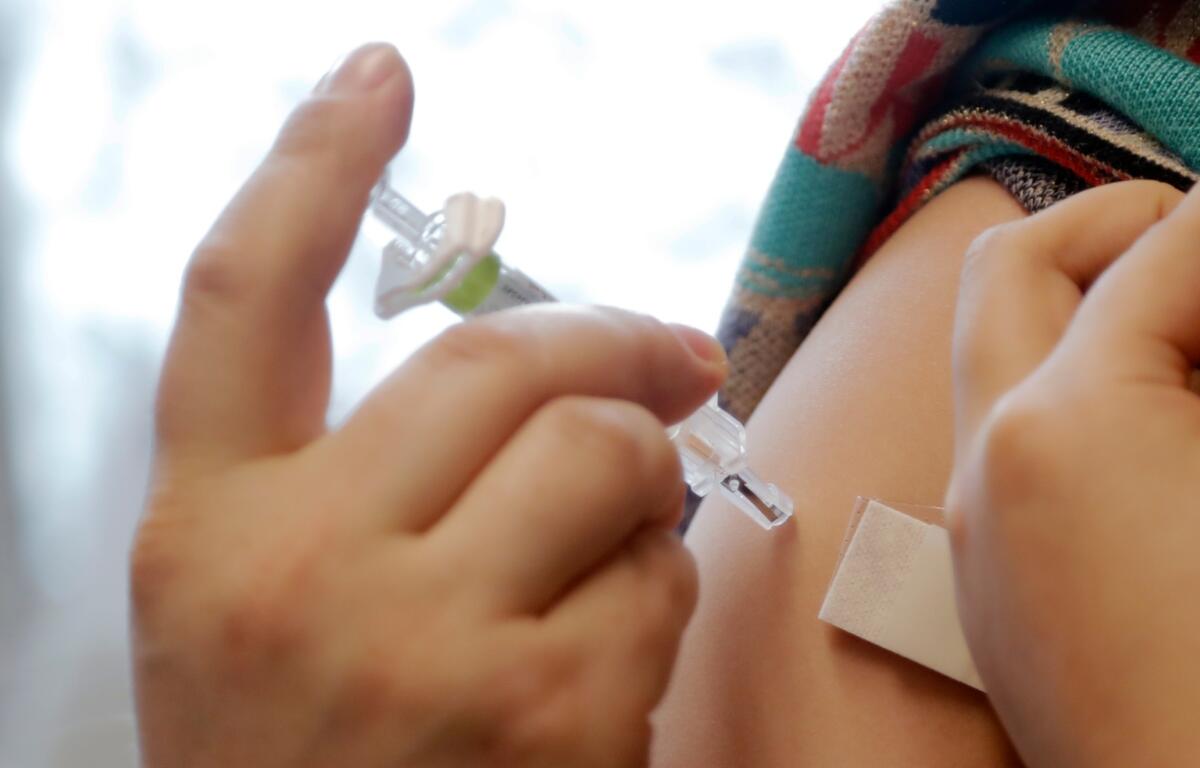 A Seattle public school student receives a chickenpox (also known as varicella) vaccine at a free immunization clinic Monday, Dec. 30, 2019, in Seattle. The school district provided the vaccination clinic ahead of the "exclusion date" of Jan. 8, 2020, when student records must reflect updated immunization status or students cannot attend school. Students will be excluded from school until they are fully vaccinated, are in the process of completing immunizations or have a Certificate of Exemption. (AP Photo/Elaine Thompson)