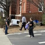 An Asheville animal services vehicle and two city forensic vehicles are seen in the parking lot of an apartment complex off Merrimon Avenue Tuesday afternoon, where a man wearing a vest marked “POLICE” escorted individuals from the vehicles.