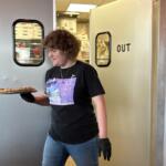 Maddie Hayler, a senior at UNC Asheville, delivers food and checks on customers at Pizza Mind.
