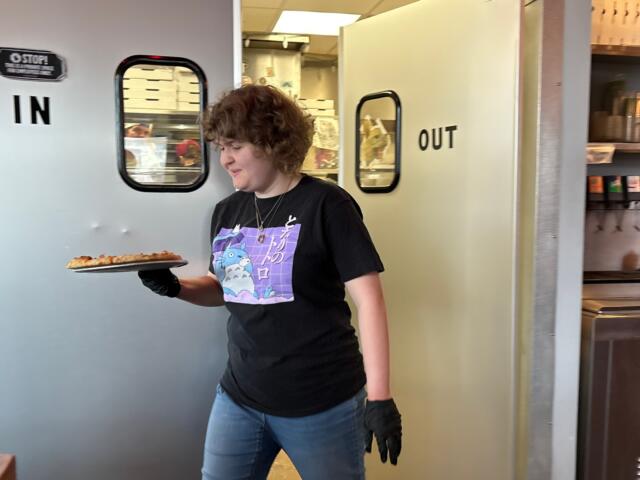 Maddie Hayler, a senior at UNC Asheville, delivers food and checks on customers at Pizza Mind.