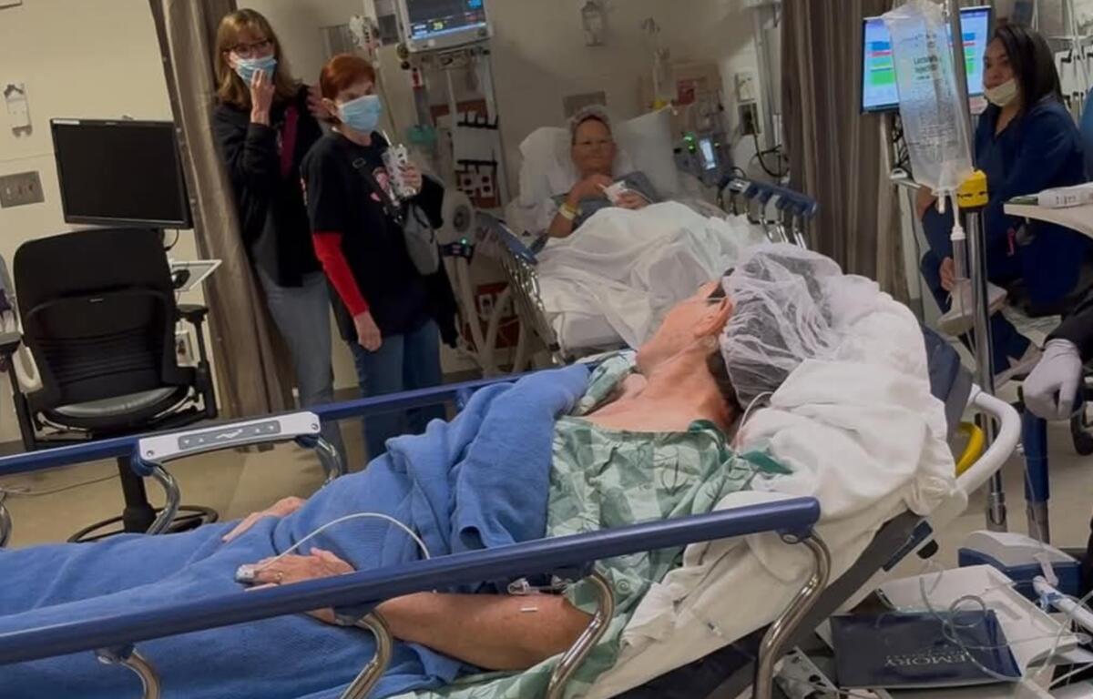 Mary Love, foreground, checks on her spouse Deb after kidney transplant surgery.