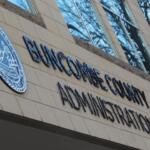 Facade of a government building showing the 'BUNGOMA COUNTY ADMINISTRATION' sign and a blue circular seal on a beige tiled wall.