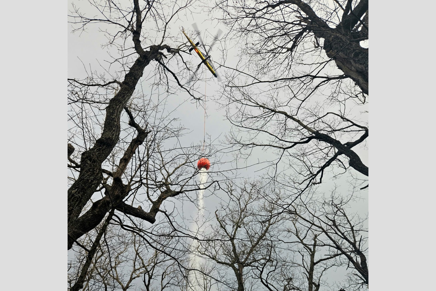 Helicopter making a water bucket drop on the Kitsuma Fire. (Photo credit: U.S. Forest Service/Matt Switzer)