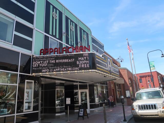 Facade of the Appalachian Theatre with a red APPALACHIAN sign and a marquee promoting a show on a sunny street.