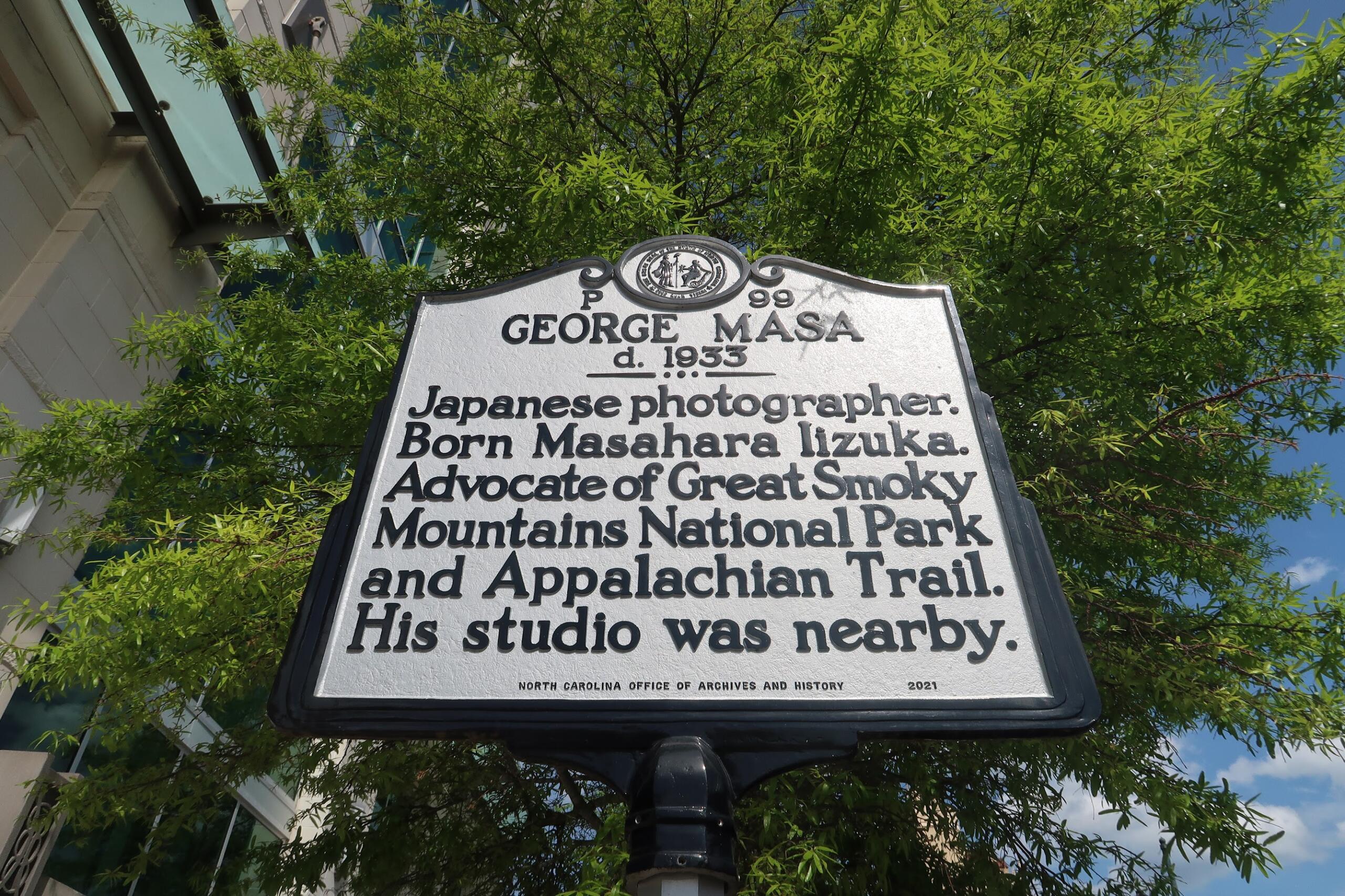 Historic marker: 'George Masa'—Japanese photographer. Born Masahara Iizuka. Advocate of Great Smoky Mountains National Park and Appalachian Trail. His studio was nearby. North Carolina Office of Archives and History 2021.