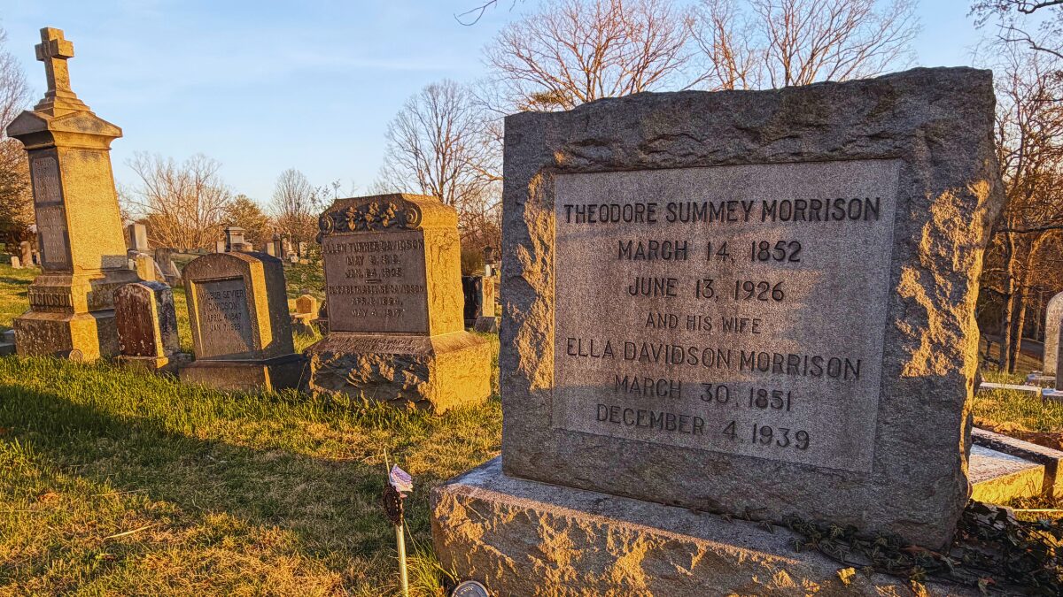 Granite grave marker in a sunny cemetery, reads Theodore Sum­mey Morrison (1852–1926) and Ella Davidson Morrison (1851–1939) with other worn headstones nearby.