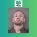 Mugshot of a man with short hair and beard against a gray cinder block wall, wearing a brown shirt; used in a news story.