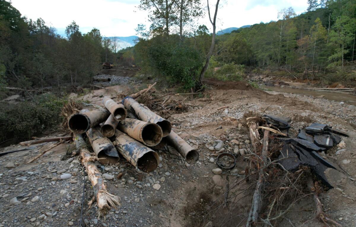 The remnants of a waterline serving Asheville, N.C., is piled up downstream from North Fork Reservoir, a main source of water for the city, Wednesday, Oct. 2, 2024, after the line was destroyed during Hurricane Helene in Black Mountain, N.C. (AP Photo/Jeff Roberson)