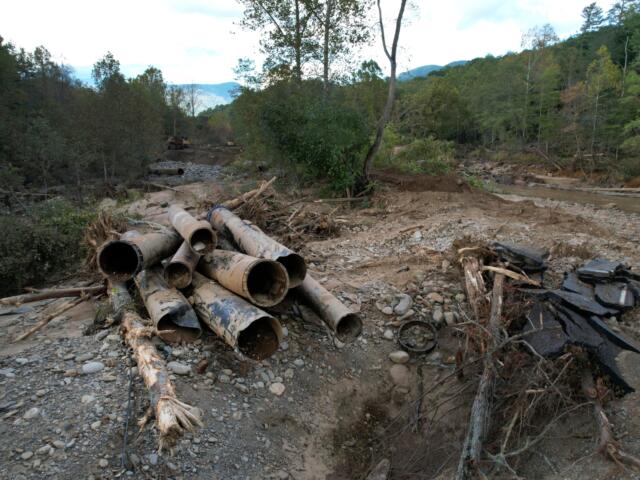 The remnants of a waterline serving Asheville, N.C., is piled up downstream from North Fork Reservoir, a main source of water for the city, Wednesday, Oct. 2, 2024, after the line was destroyed during Hurricane Helene in Black Mountain, N.C. (AP Photo/Jeff Roberson)