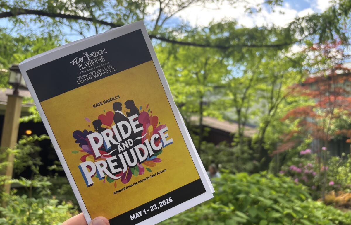 Outdoor poster for Pride and Prejudice by Jane Austen, held by a hand against a leafy background.