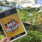 Outdoor poster for Pride and Prejudice by Jane Austen, held by a hand against a leafy background.