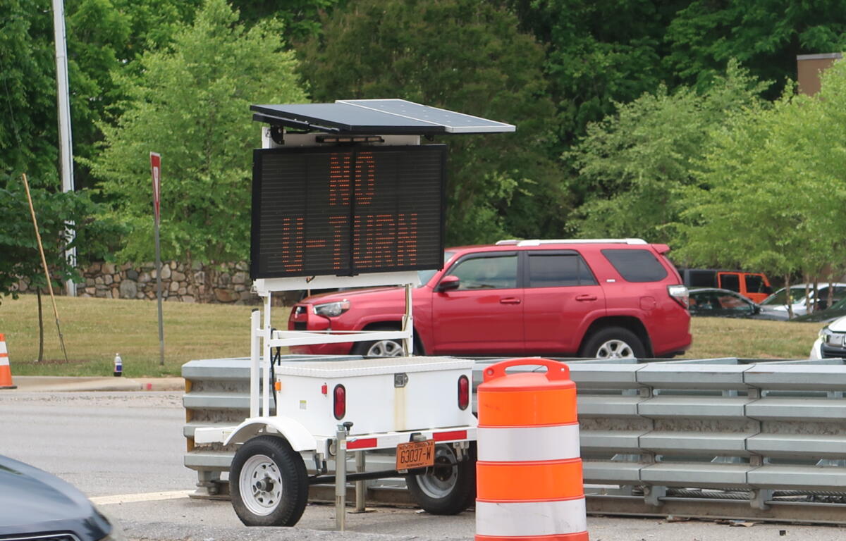 LED variable-message sign on a trailer with a solar panel top in a construction zone.