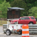 LED variable-message sign on a trailer with a solar panel top in a construction zone.