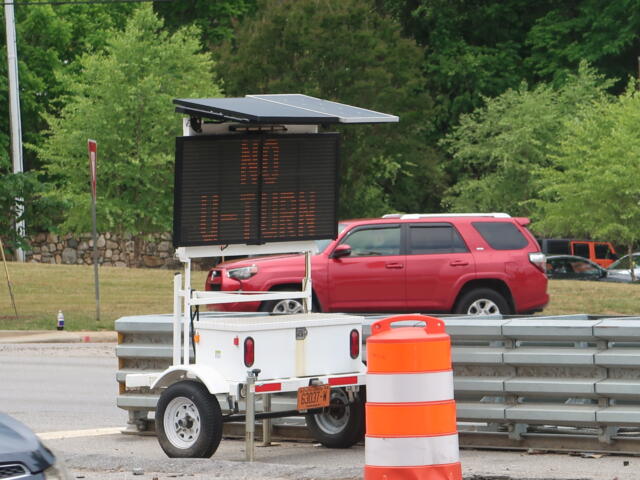 LED variable-message sign on a trailer with a solar panel top in a construction zone.