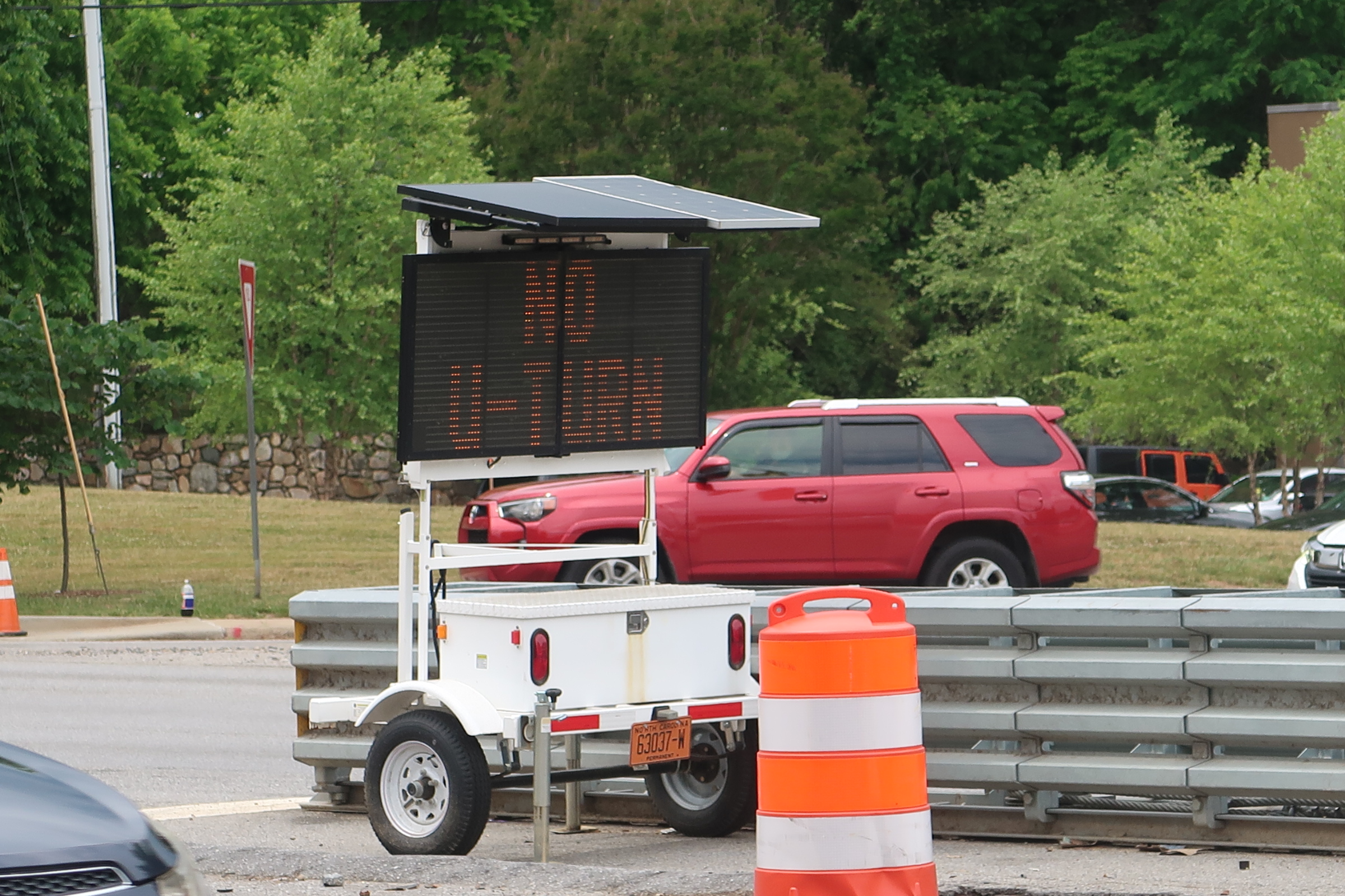 LED variable-message sign on a trailer with a solar panel top in a construction zone.