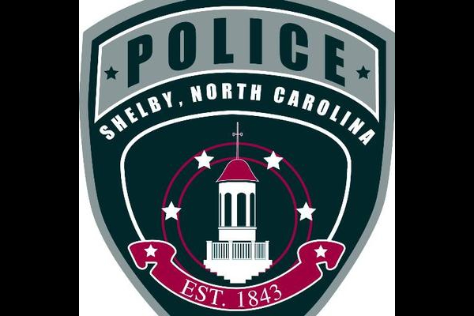 Shield-shaped police emblem for Shelby, North Carolina, with a central white courthouse tower, stars, and EST. 1843 text