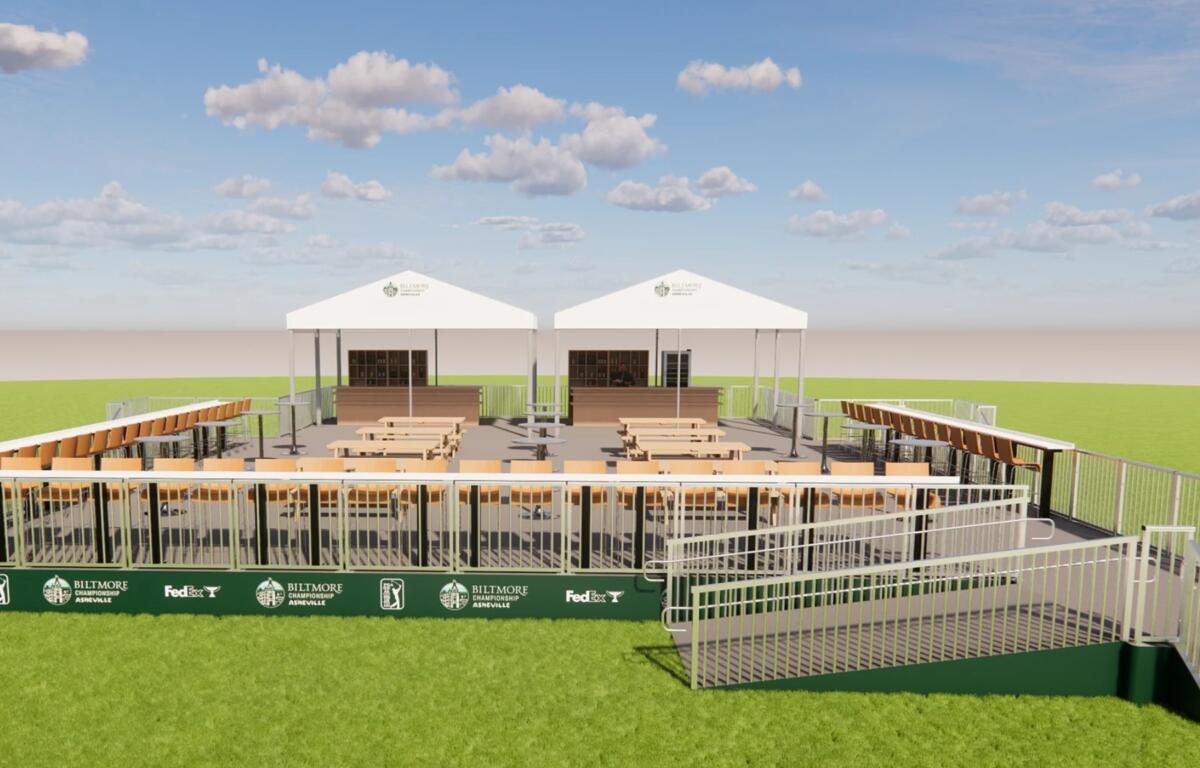 Two white event tents sit behind rows of wooden bleachers on a grassy field under a blue sky with scattered clouds, at a sports venue.
