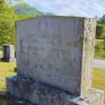 Weathered granite tombstone in a sunny grassy cemetery, inscribed with Amos Lunsford and family dates and the word 'Father'/'Mother'.