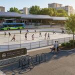 People skate on an outdoor rink surrounded by trees and pedestrians, with a city bus and buildings in the background.